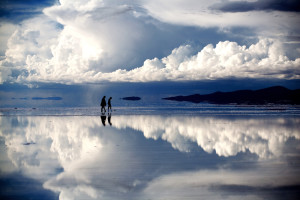 Two people walk in contemplation in the dream world of the Salar de Uyuni, Bolivia